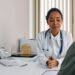 A female doctor consulting a patient in a modern medical office setting.